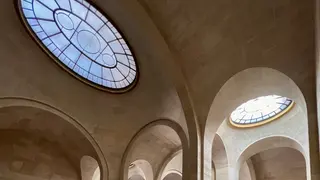 Arched stone ceilings are illuminated by two oval stained-glass skylights.
