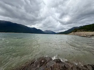 A body of water with waves under a cloudy sky.