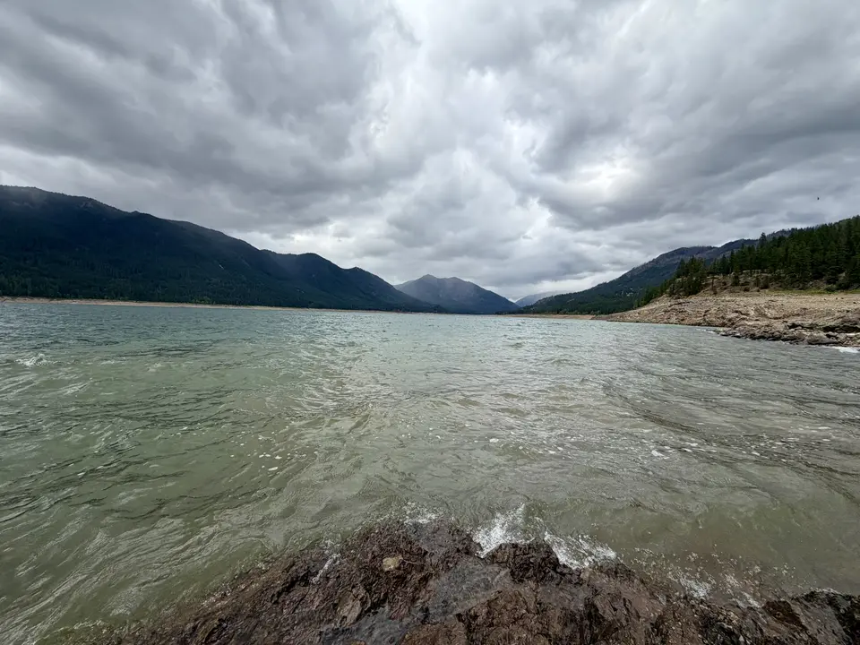 A body of water with waves under a cloudy sky.
